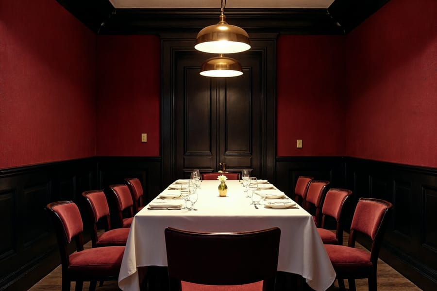 Private windowless dining room with a closed door behind a long linen table